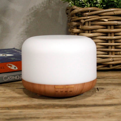 Elegant Aarhus essential oil diffuser on a wooden surface with books and a basket in the background for home wellbeing - Kraas