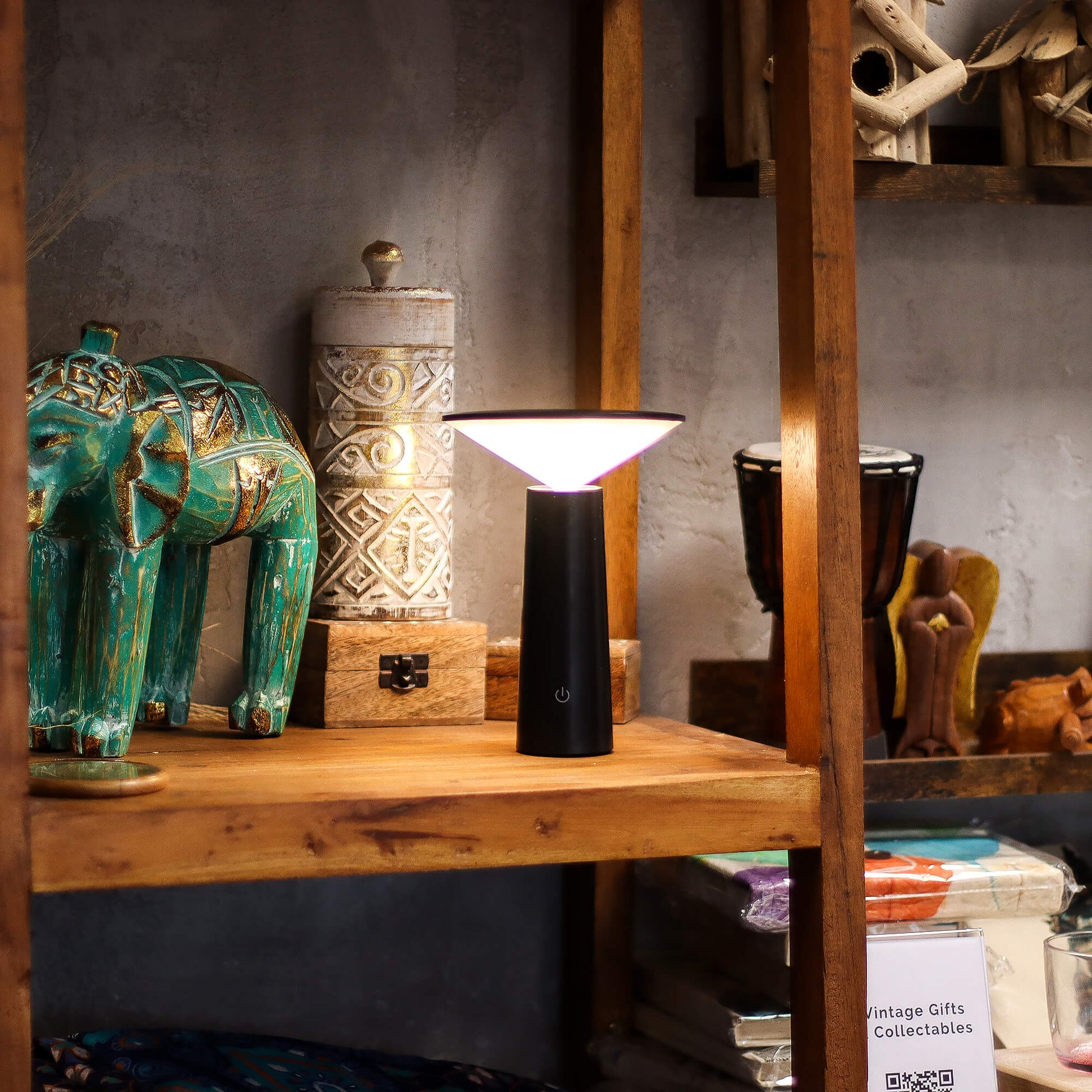 Black tall adjustable LED lamp on a wooden shelf adding elegant lighting to modern home décor - Kraas