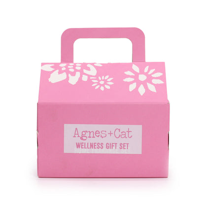 Pink gift box with white floral designs and 'Agnes + Cat Wellness Gift Set' label on a white background - Agnes and Cat