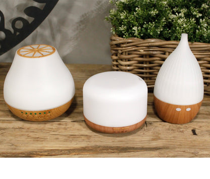 Three white portable essential oil diffuser The Atomiser for modern interiors on a wooden surface - Kraas