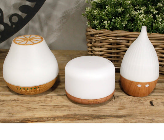 Three white portable essential oil diffuser The Atomiser for modern interiors on a wooden surface - Kraas