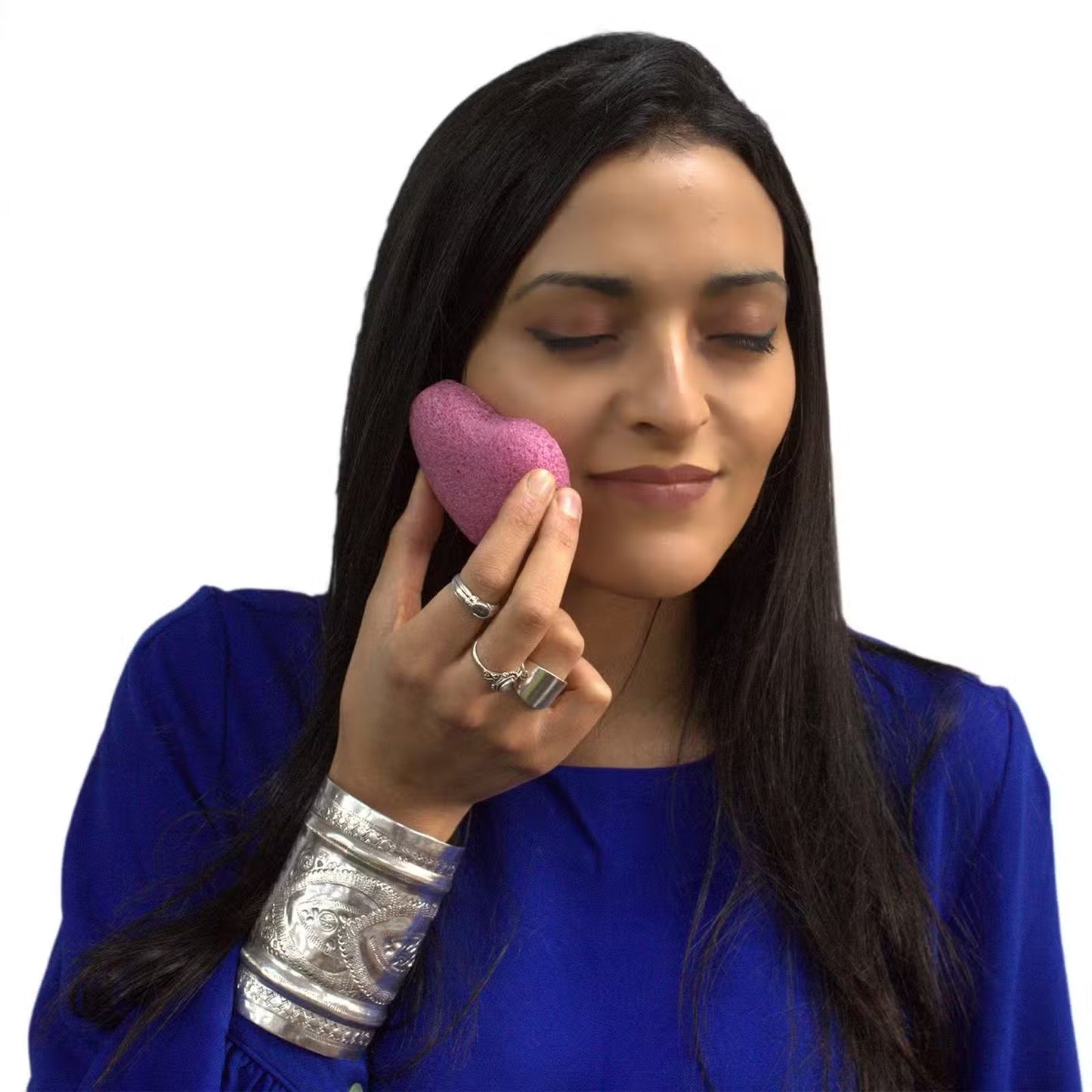 Woman applying soft pink konjac sponge to face for skincare cleansing and hydration - Kraas