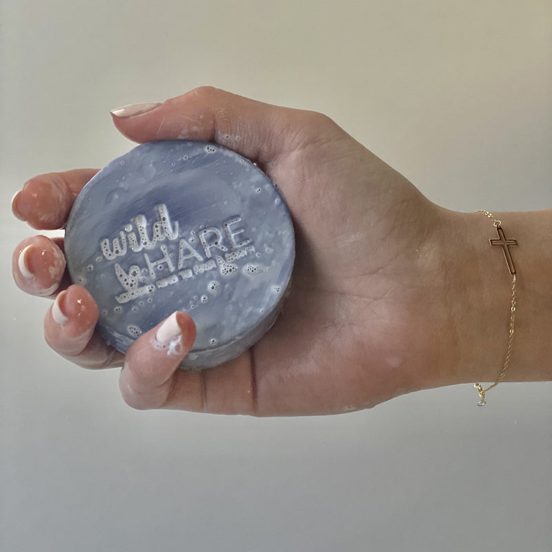 Eco-friendly shampoo bar Hand holding 'wild hare' for healthy, nourished and chemical free hair - Ancient Wisdom