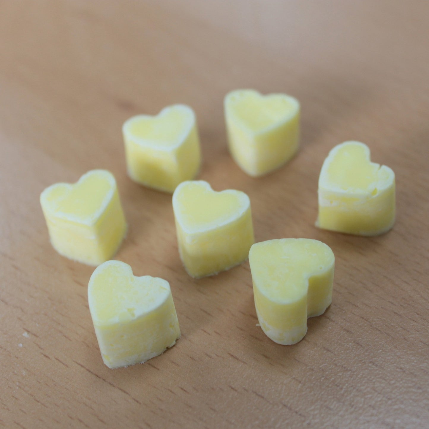 Heart shaped yellow colour wax melts cosy ambient home décor scent on a wooden surface - Ancient Wisdom