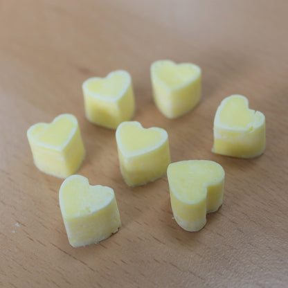 Heart shaped yellow colour wax melts cosy ambient home décor scent on a wooden surface - Ancient Wisdom