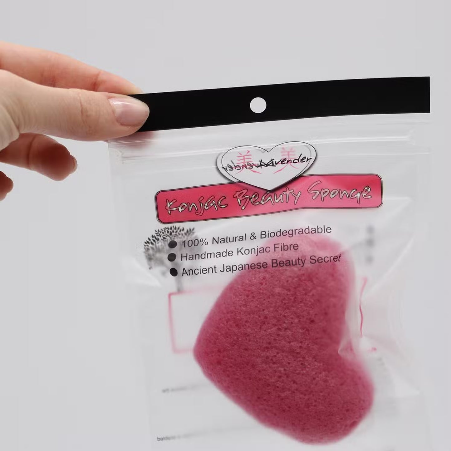 Natural Japanese konjac beauty sponge in packaging a hand holding top corner for gentle facial cleansing and exfoliation - Kraas