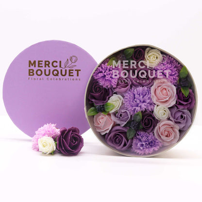 Round container of lavender soap flowers with a purple lid featuring 'Merci Bouquet' branding - Ancient Wisdom