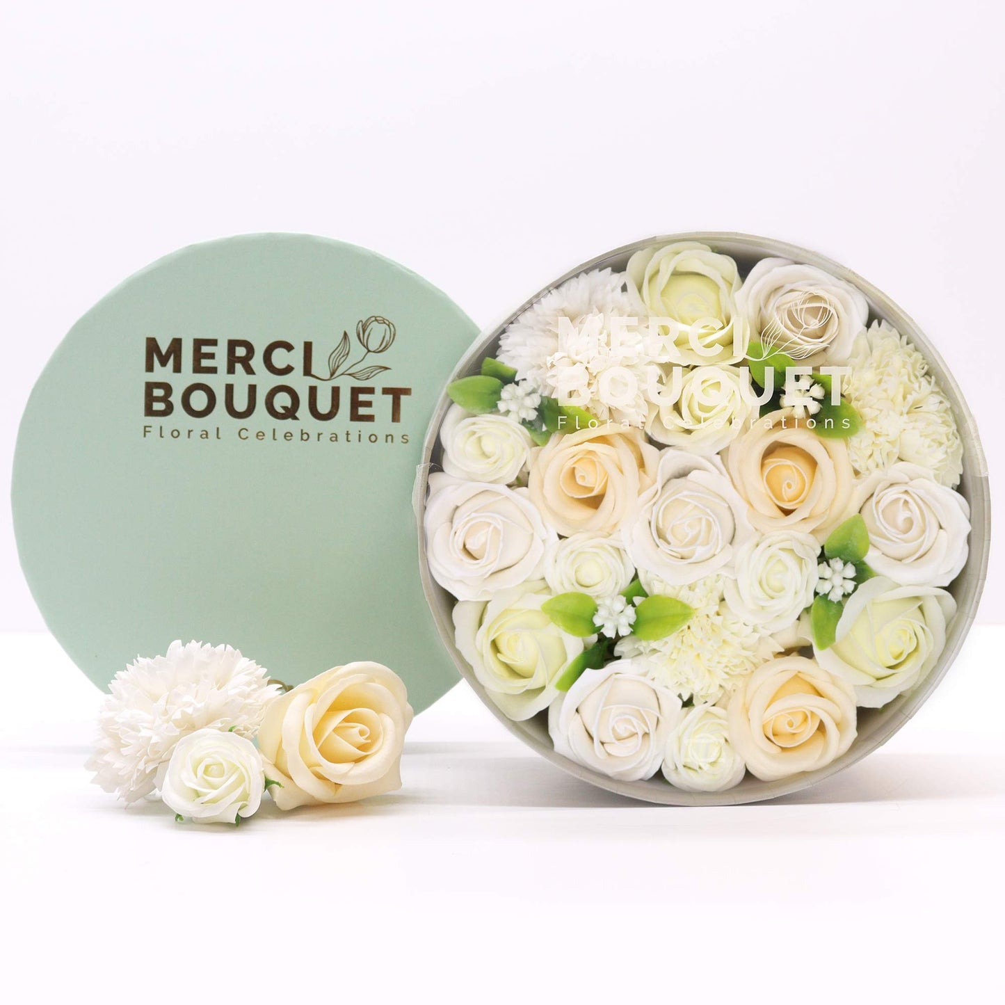 Fragrant soap flowers displayed in an elegant keepsake round gift box of white and ivory flowers soap with a light green lid labeled 'Merci Bouquet' - Ancient Wisdom