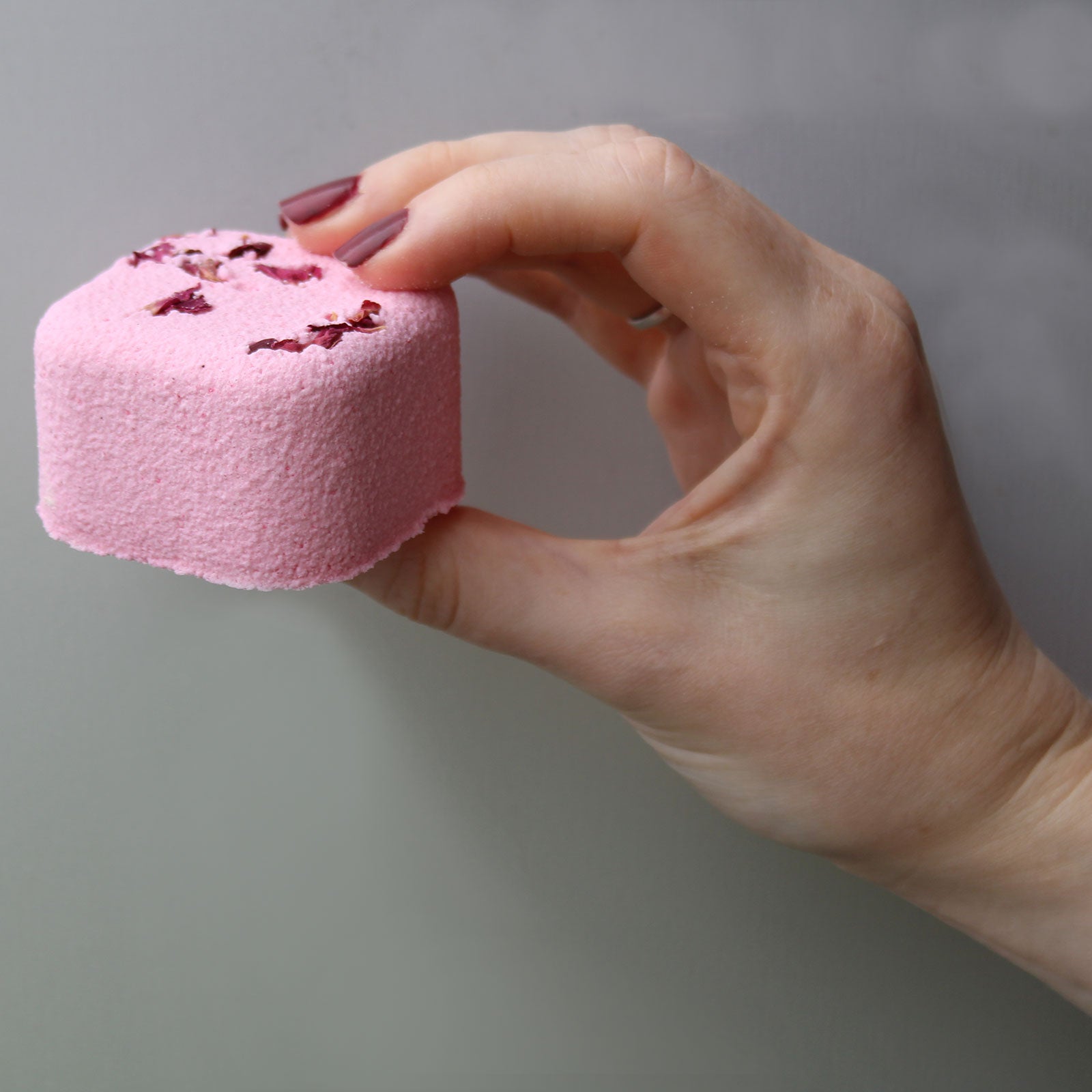 Woman hand holding pink steamy shower steamer - Kraas